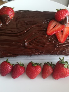 A picture of Brazo de gitano marmolado relleno de nata y fresas con chocolate.