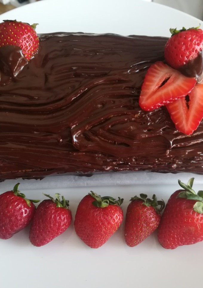 Una foto de Brazo de gitano marmolado relleno de nata y fresas con chocolate