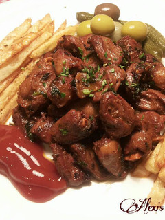 Una foto de Corazones de pollo aliñados con patatas fritas