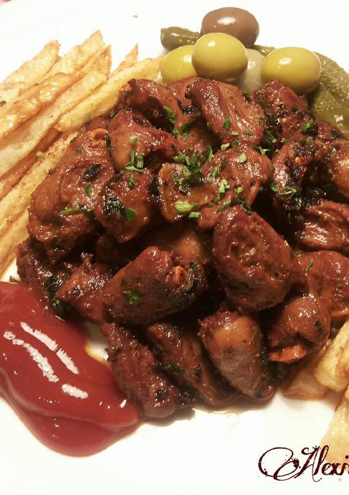 Una foto de Corazones de pollo aliñados con patatas fritas