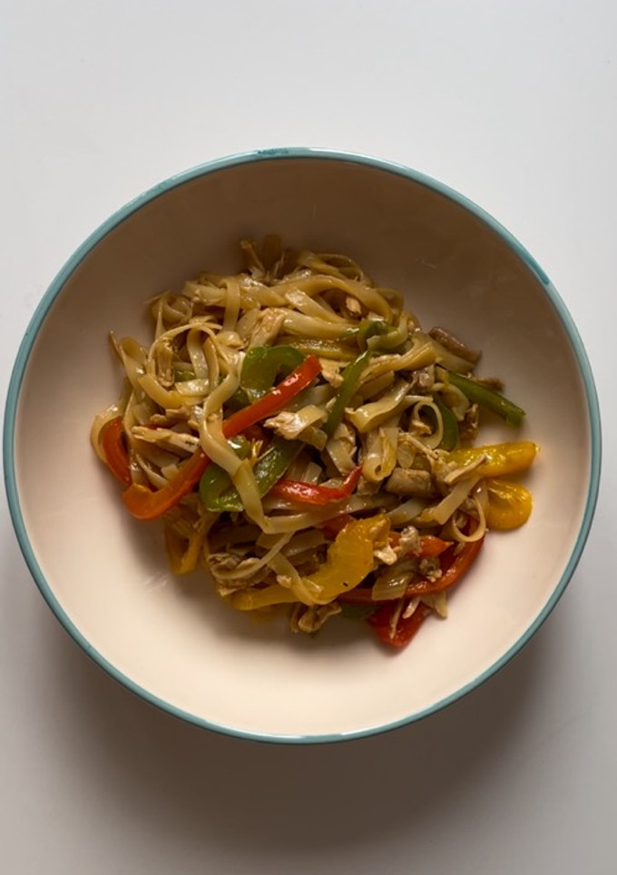 Una foto de Noodles de arroz con pimientos y pollo