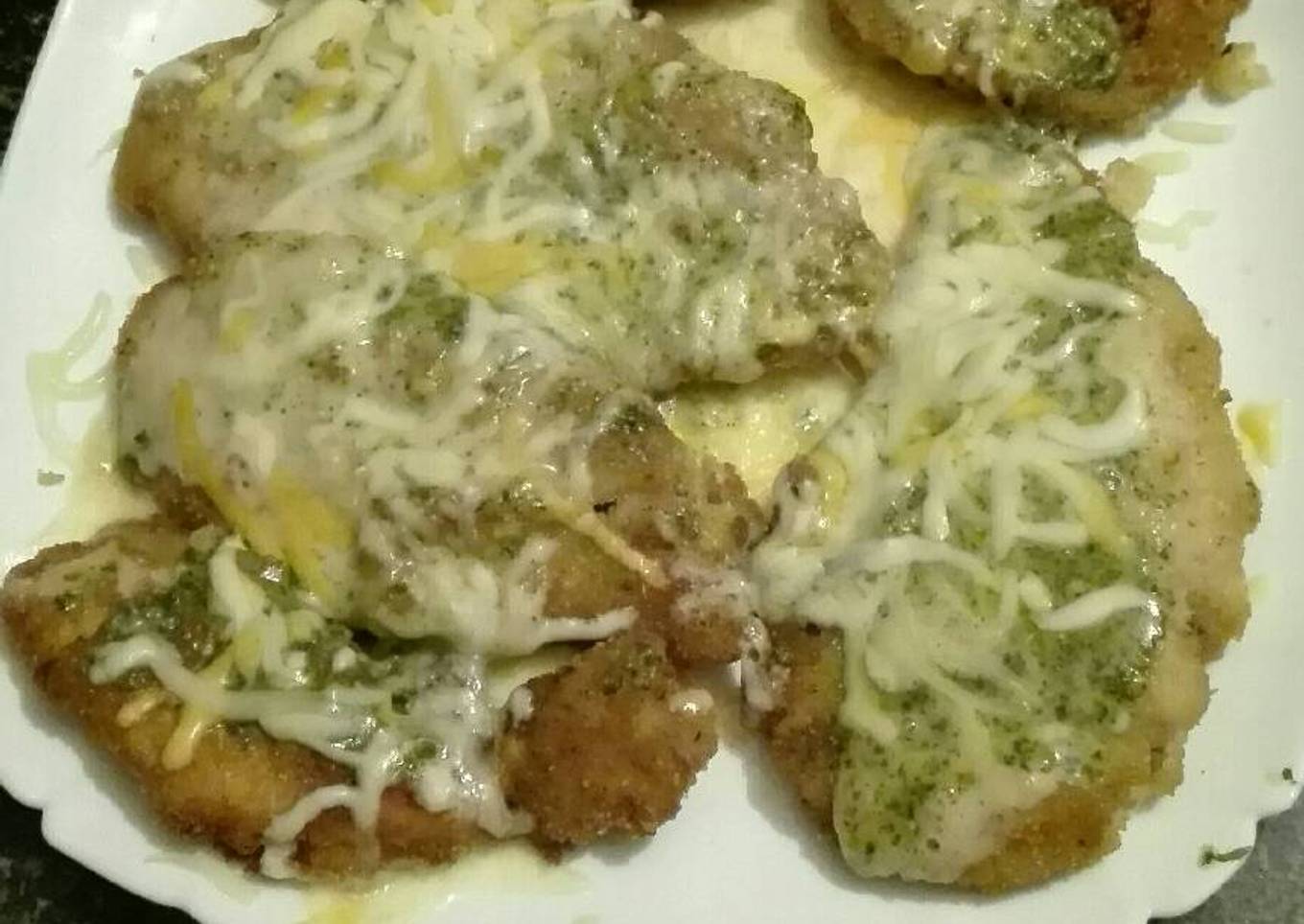 Filetes de pechuga empanados con mostaza, queso fundido y salsa pesto