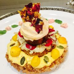 A picture of Ghewar cake with gulkand and mango rabdi mousse.