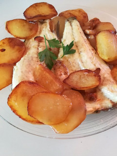 Una foto de Lubina al horno con patatas panadera