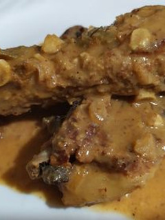 Una foto de Costillas de cerdo con salsa de jugo de naranja y semillas de girasol, ajonjolí y nuez