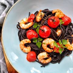 A picture of Squid Ink Spaghetti With King Prawns, Vine Tomatoes & Chilli.