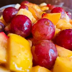 A picture of Fruit Salad with Grapes 🍇 banana 🍌, apple 🍎, peach 🍑 & mango 🥭.