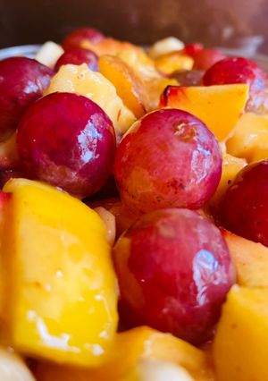 A picture of Fruit Salad with Grapes 🍇 banana 🍌, apple 🍎, peach 🍑 & mango 🥭.