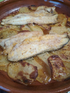 Una foto de Lubina al horno con patatas panaderas