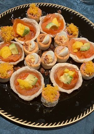 Una foto de Canapés de salmón marinado, pulpo, mango y aguacate