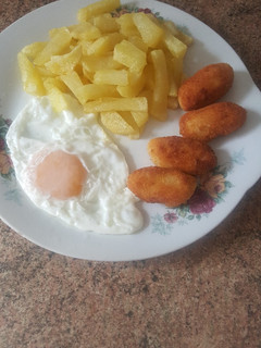 Una foto de Patatas fritas con huevo frito y croquetas