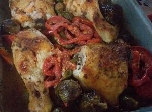 Una foto de Pollo asado con guarnición de cebollines, tomates y coles de Bruselas