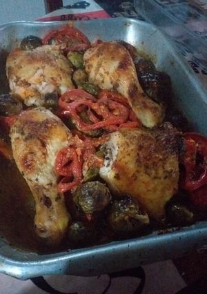 Una foto de Pollo asado con guarnición de cebollines, tomates y coles de Bruselas