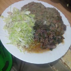 A picture of Mashed githeri with meat stew and steamed cabbage.