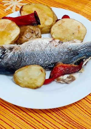 Una foto de Lubina al horno con papas y pimiento