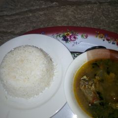 A picture of White Rice with Goat meat and Assorted Pepper Soup.
