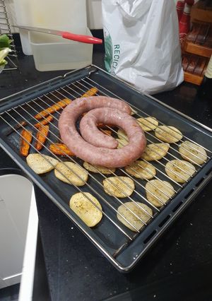Una foto de Butifarra al horno con patatas y zanahoria