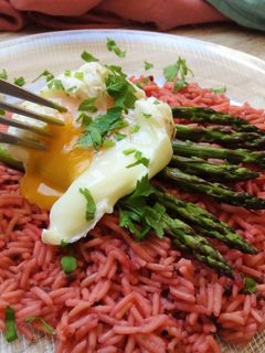 Una foto de Arroz de remolacha con espárragos trigueros y huevo poché