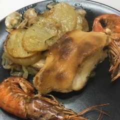 Una foto de Lomo de bacalao gratinado con cama de cebolla, patata, almejas y gambas