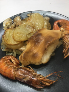 Una foto de Lomo de bacalao gratinado con cama de cebolla, patata, almejas y gambas