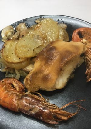 Una foto de Lomo de bacalao gratinado con cama de cebolla, patata, almejas y gambas