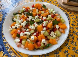 Une photo de Salade composée de melon, tomates, concombre, oignon doux, feta et menthe