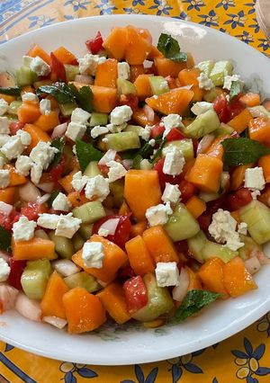 Une photo de Salade composée de melon, tomates, concombre, oignon doux, feta et menthe