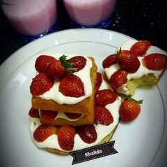 A picture of Strawberry Shake and vanilla Cheesecake with strawberries.
