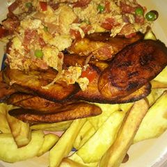 A picture of Fried potatoes and plantain with egg sauce and green peas.