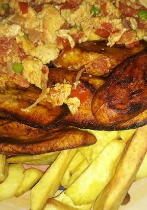 A picture of Fried potatoes and plantain with egg sauce and green peas.