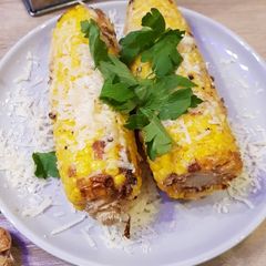 A picture of Cheesy, garlicky corn on the cob.
