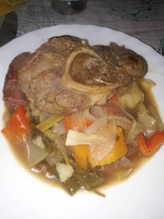 Una foto de Osobuco con vegetales y vino tinto
