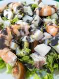 Ensalada de pescado y marisco con salsa negra