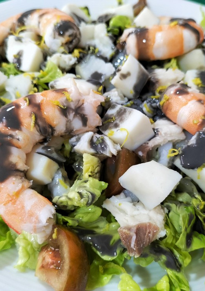 Una foto de Ensalada de pescado y marisco con salsa negra