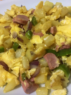 A picture of Scrambled egg with potato and sausages.