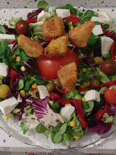 Una foto de Ensalada con crujientes de quesito y caqui