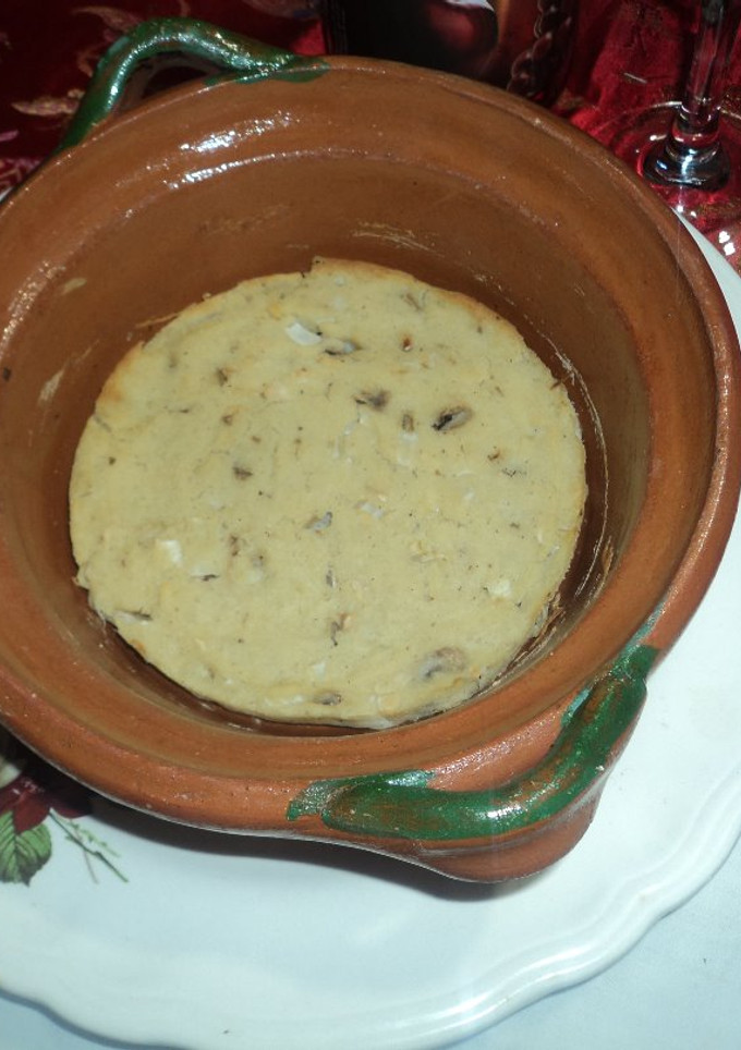 Una foto de Tamal de cazuela prehispánico de hongos, cebolla, epazote,  cacahuate con masa blanca. Comida vegana