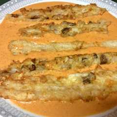 Una foto de Espárragos rellenos de setas con salsa de piquillos