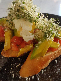 A picture of Avomato Bruschetta With Poached Egg And Alfalfa.