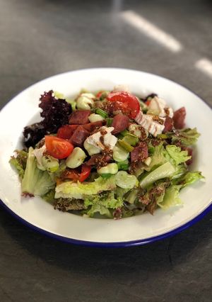 A picture of Basque sausage, goats cheese, broad bean and spring onion salad.