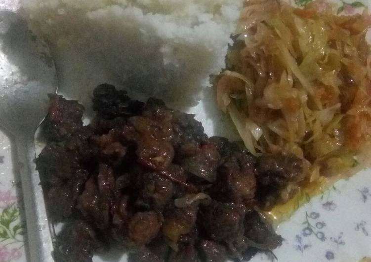 Fried beef served with ugali and fried cabbage