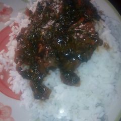 A picture of White rice and ugwu stew.