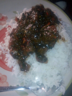 A picture of White rice and ugwu stew.