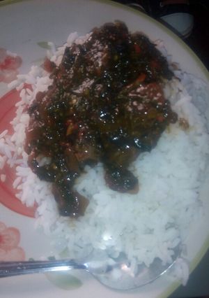 A picture of White rice and ugwu stew.