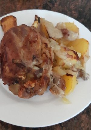 Una foto de Codillo asado, con papas y cebolla
