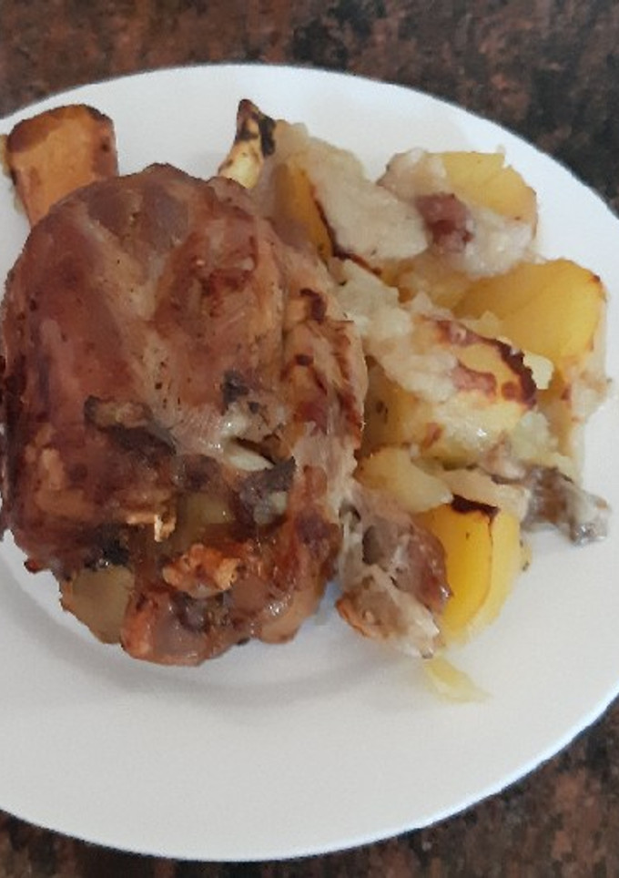 Una foto de Codillo asado, con papas y cebolla