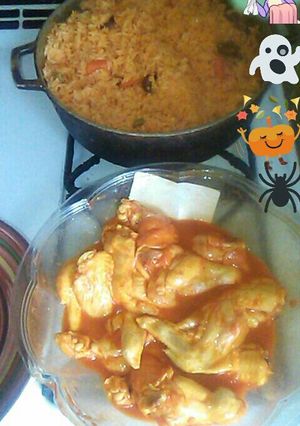 A picture of Yellow rice w carrots and sauces n spicy buffalo wing.