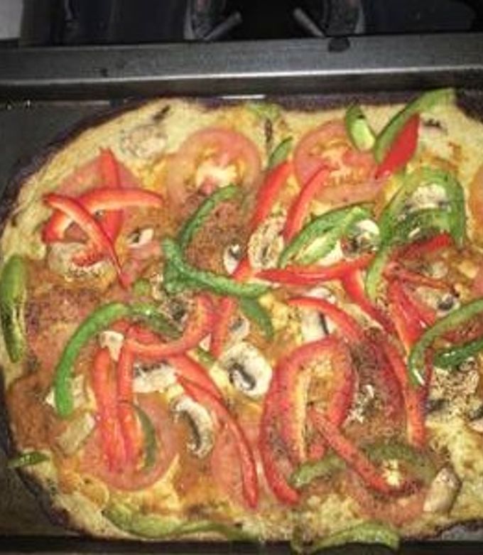 Una foto de Pizza baja en carbohidratos sin gluten -harina de coliflor cubierta de vegetales