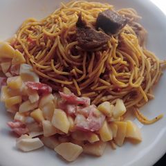 A picture of Jollof spaghetti with beef and potato salad.