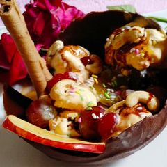 A picture of Chocolate bowl with fruits and nuts and Icecream.